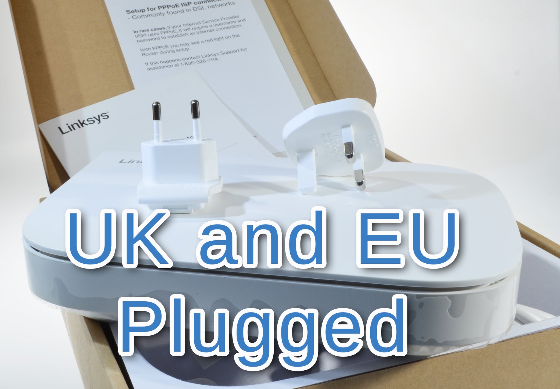 Linksys router with UK and EU plugs on top of a cardboard box